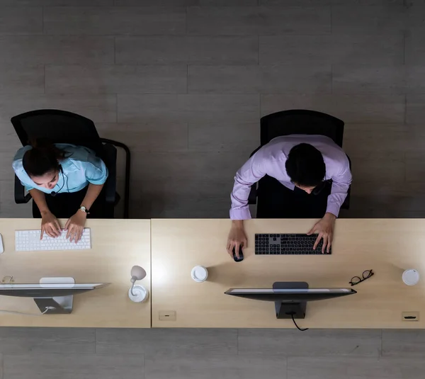 Late Night Environment, Top view of call centre operator team with headsets working in a call centre customer service and technical support. Using for 24 Hr. Call center Concept.