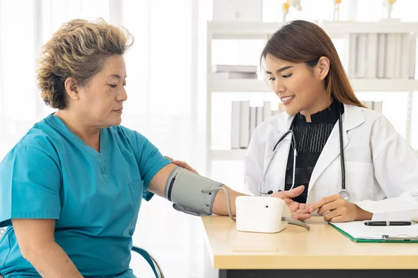 Vrouwelijke Arts Die Bloeddruk Meet Van Oudere Vrouwen Een Onderzoekskamer — Stockfoto