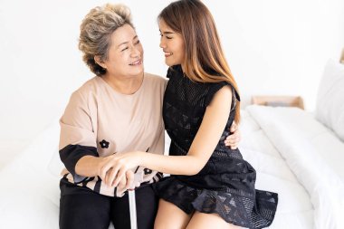 Sevimli genç kız kucaklıyor mutlu yaşlı annesine evde sevgiyle sarılıyor.