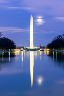 Washington Anıtı, gün batımında Lincoln Memorial 'dan gelen yeni yansıtma havuzunda sergilenmektedir. Bu anıt, Washington DC ABD' nin ulusal alışveriş merkezinin bir simgesidir..