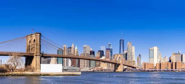 ブルックリン橋とロウアー マンハッタンの高層ビル群の街並みがニューヨーク市を賑わせている ロウアー マンハッタンは世界最大の金融街である — ストック写真