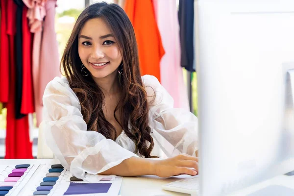 作为唯一的主人 年轻的亚洲服装设计师制造商与她的电脑一起在她的工作室里工作 工作室里有彩色调色板 对创业者使用小企业创业概念 — 图库照片