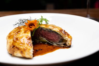 Sos soslu kızarmış sığır eti Wellington, fırında pişmiş ekmeğin içine sığır eti konmuş uluslararası gurme mutfağı. Tarif menüsü için birleşme pf gıda ve içecek endüstrisi.