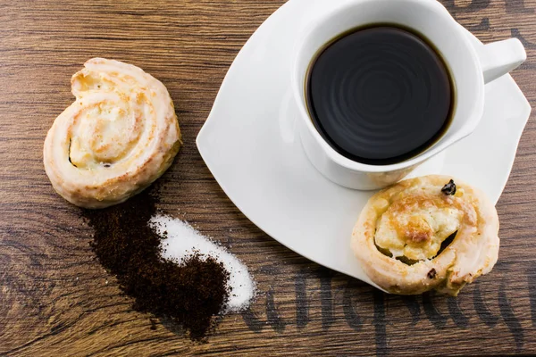 cup of coffee with cake on wooden table