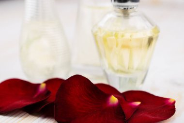 Gül leafes ve ahşap zemin üzerine parfüm