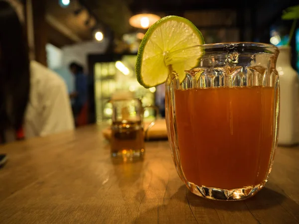 Гарячий лимонний чай має шматочок лимона на склянці з медом на дерев'яному столі — стокове фото