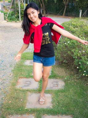 Asyalı kadın kaldırım bahçede oynarken