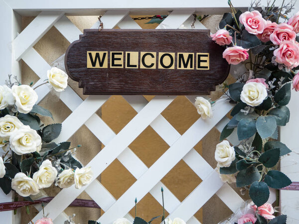 Wooden board have a label "Welcome" and flower