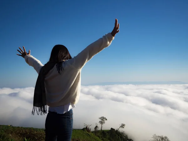 Asiatische Frau drückt ihre Hand nach oben und blickt auf Nebelmeer, Nebelhintergrund — Stockfoto