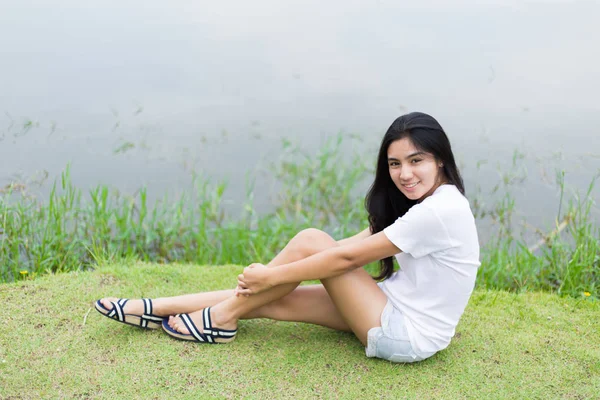Mujer asiática sentada en la hierba —  Fotos de Stock