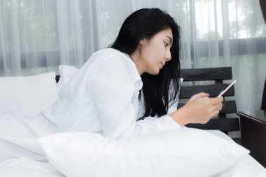 Kadın parlak yatak odasında bir kısa mesaj okuma