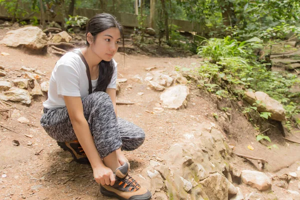 Asian kobieta krawat jej buty w lesie — Zdjęcie stockowe