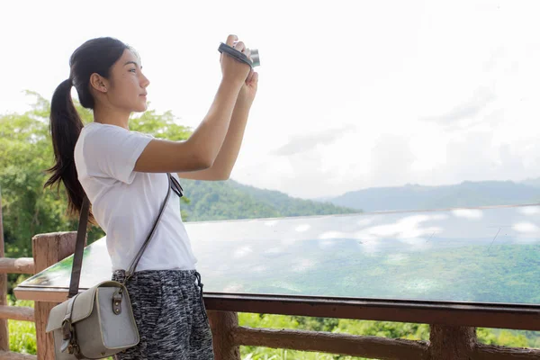 Kobieta wycieczkowicz biorąc zdjęcie z kamery w góry — Zdjęcie stockowe
