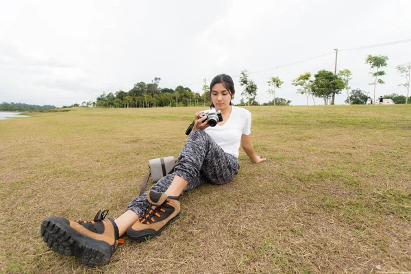 Açık havada fotoğraf çekmek için bir kamera kullanan kadın