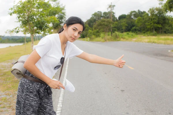 Güzel genç Asyalı kadın turist bir araba bekliyor
