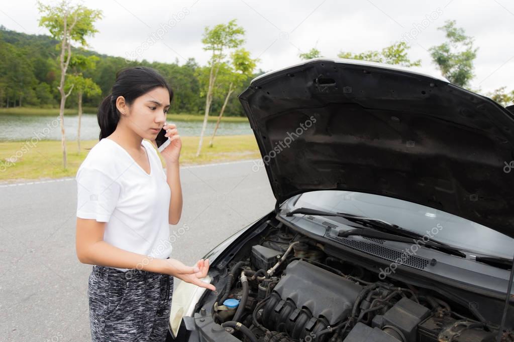 Woman after a car breakdown at the side of the road
