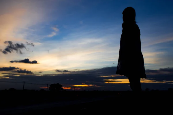 Silhouette einer Frau, die bei Sonnenuntergang oder Sonnenaufgang posiert — Stockfoto