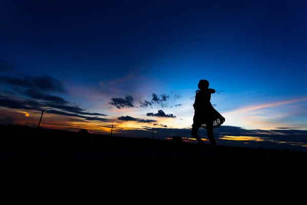 Silhouette einer Frau, die bei Sonnenuntergang oder Sonnenaufgang posiert — Stockfoto