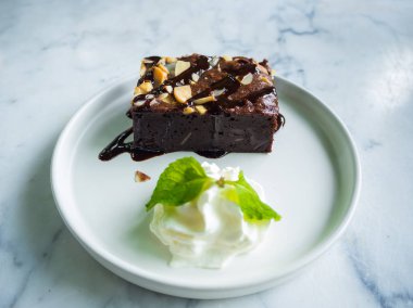 Beyaz masada beyaz tabakta kek dilimlenmiş