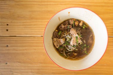 Ahşap arka plan üzerinde seramik bir kasede Asya Erişte