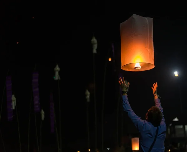 Asian man holding floating sky lanterns during Loy Kratong Festi Stock Image