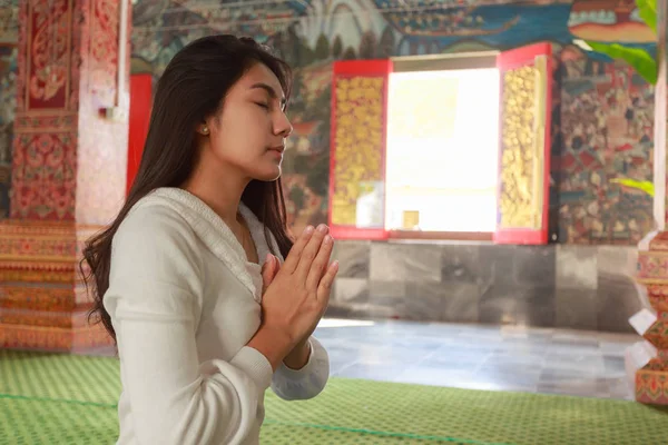 Asian woman pay homage to a Buddha image Stock Picture