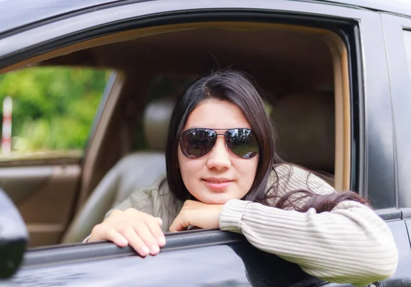 Asian woman protrudes from the window of the car — Stock Photo, Image