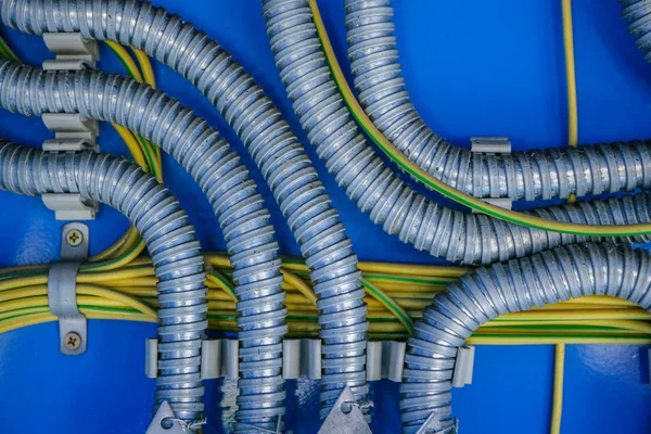 Câblage, distribution de fils dans une ondulation métallique sur fond bleu — Photo