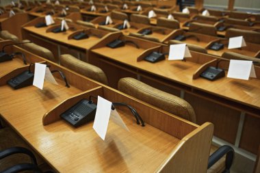 Boş bir konferans odasında mikrofon ve masalar. Oturum başlıyor. Arkaplan.