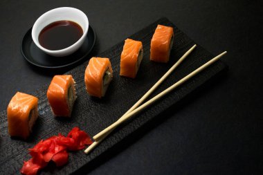 Suşi ruloları. Karanlık stil. Bir Japon restoranında yemek servisi. Kopyalamak için en üstteki görünüm. Pazarlamada minimalizm