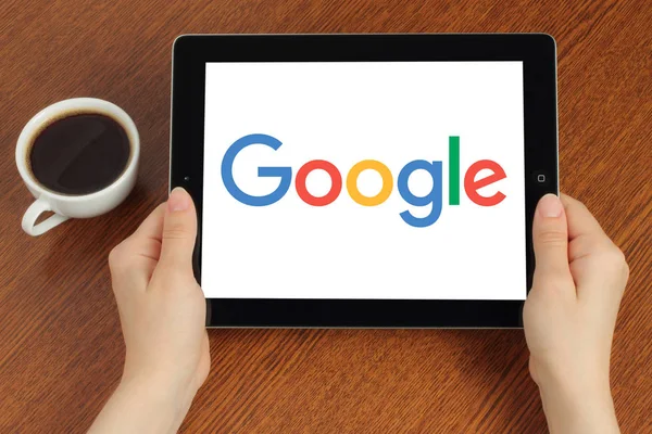 Handen houdt ipad met Google-logo op houten achtergrond — Stockfoto