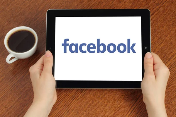 Händerna håller ipad med Facebook logotyp — Stockfoto