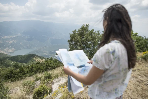 Femme avec carte au sommet de la montagne — Photo