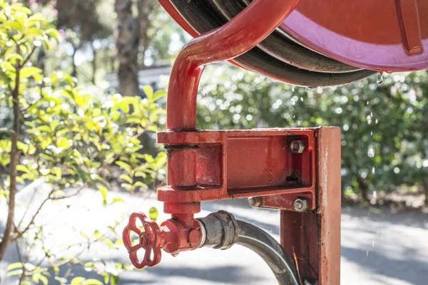 Fire extinguisher in a garden — Stock Photo, Image