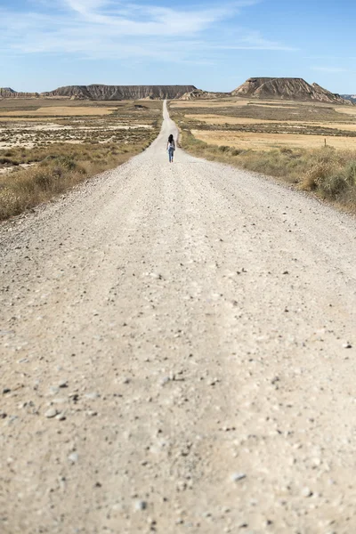Женщина ходит по грунтовой дороге . — стоковое фото