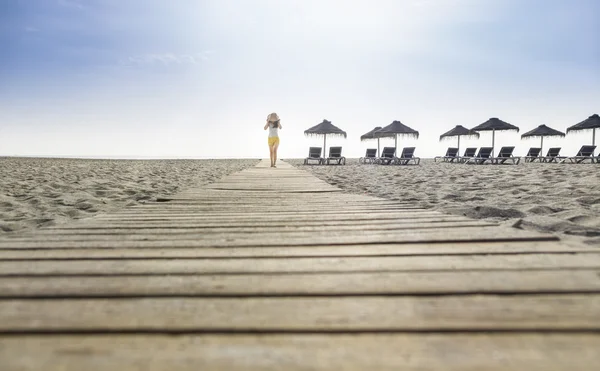 Vrouw met hoed op het strand — Stockfoto