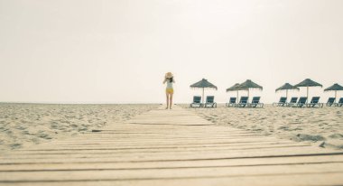 Kumsalda şapkalı bir kadın