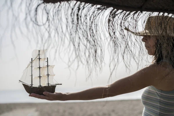 Жінка тримає модель човна на пляжі — стокове фото