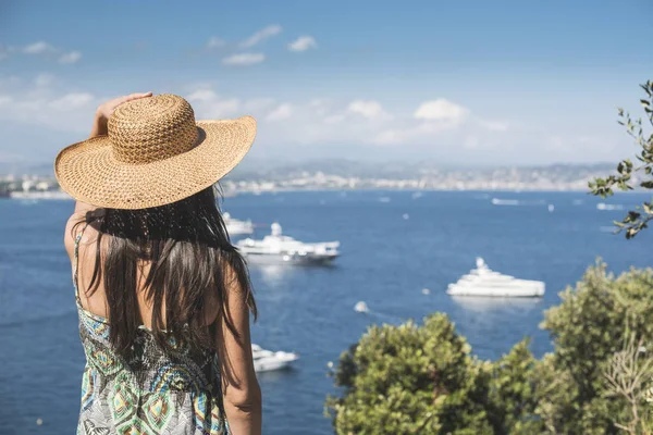 Жінка з літнім капелюхом дивиться яхти — стокове фото
