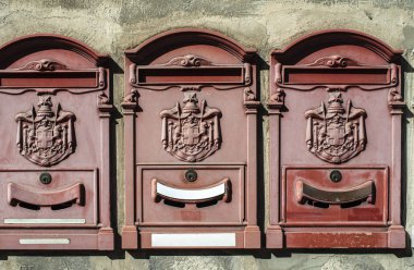 İtalya 'da eski posta kutuları. Gri yüzeyde metal kırmızı posta kutuları