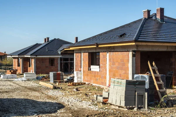 Building a new brick house with black roof. Small houses on cons Stock Image
