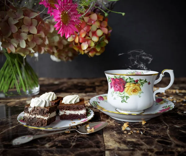 Çay pasta ve çiçekler buket ahşap masa üzerinde ile closeup kapatmak yukarıya fotoğraf — Stok fotoğraf