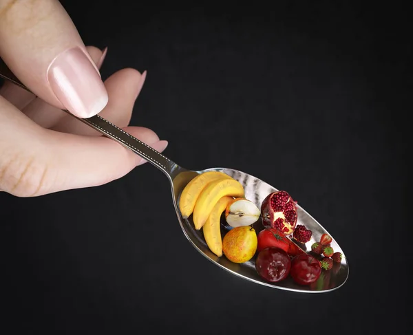 Mujer mano celebración cuchara con frutas en aislado negro concepto de dieta foto de cerca —  Fotos de Stock