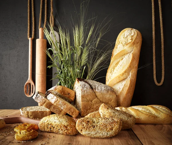 Fresh bread with wheat on a slate cutting board and photo background copy space — Stock Photo, Image