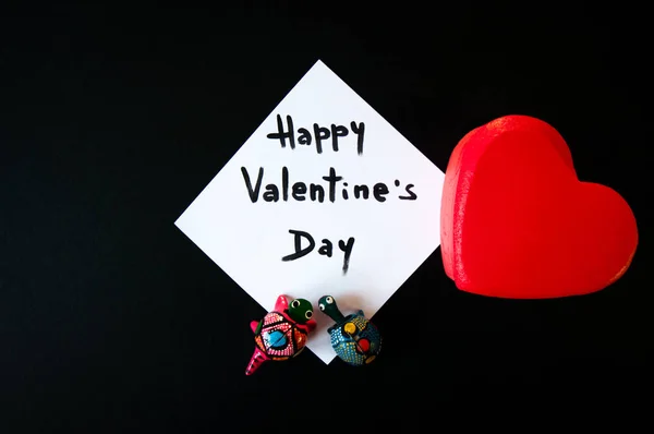 Tarjeta de día de San Valentín se muestra con un corazón rojo y dos pequeñas tortugas de juguete — Foto de Stock