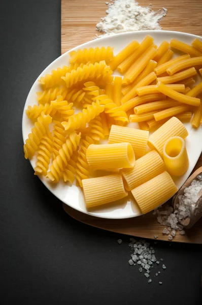 Tre typer av italiensk pasta på en vit platta — Stockfoto