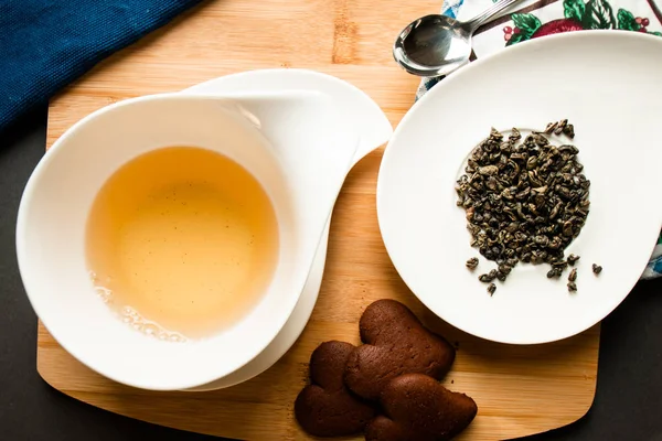 bir fincan çay ile Çikolatalı çerezleri hizmet yanında yeşil çay yaprakları