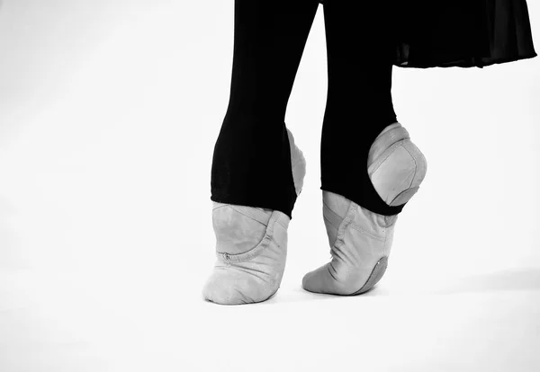 Foto en blanco y negro de pies de bailarina de ballet sobre un fondo blanco — Foto de Stock