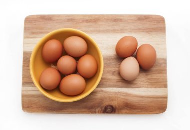 Yumurta, kahverengi yumurta sarı plaka üzerinde ahşap masa, üstten görünüm