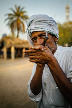 Pipo ve kameraya bakarak adam